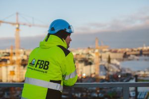 En medarbetare i varselkläder poserar vid Slussen i Stockholm