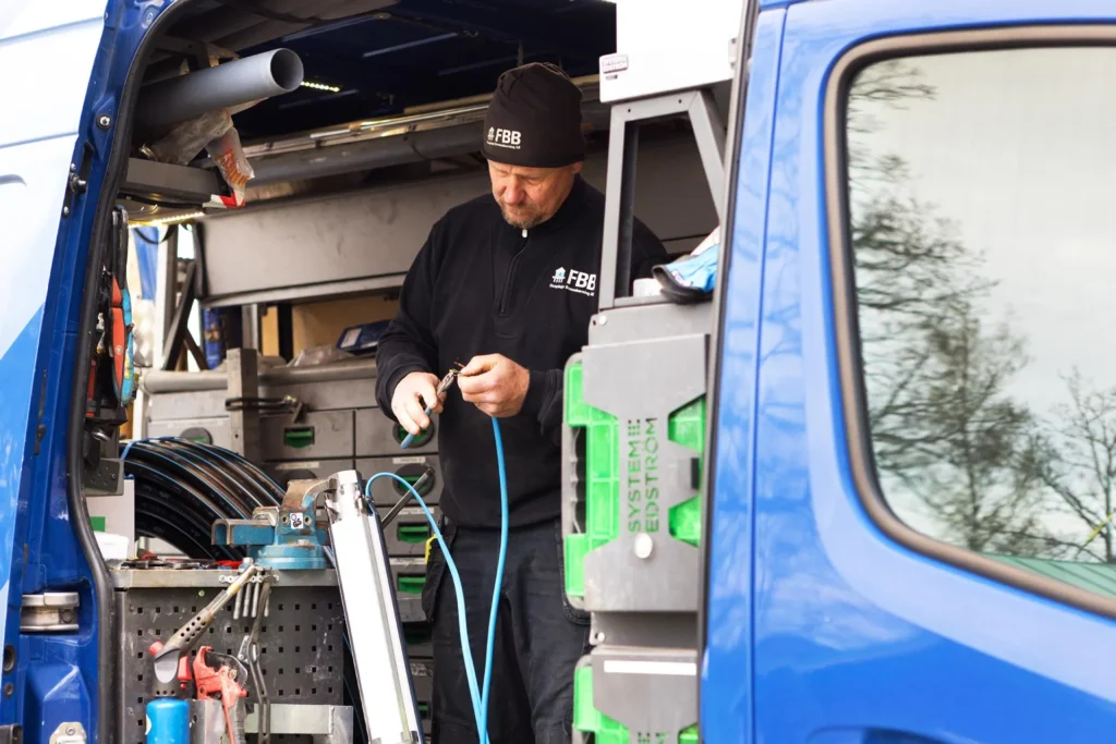 Person från FBB fixar en kabel ståendes i sitt arbetsfordon