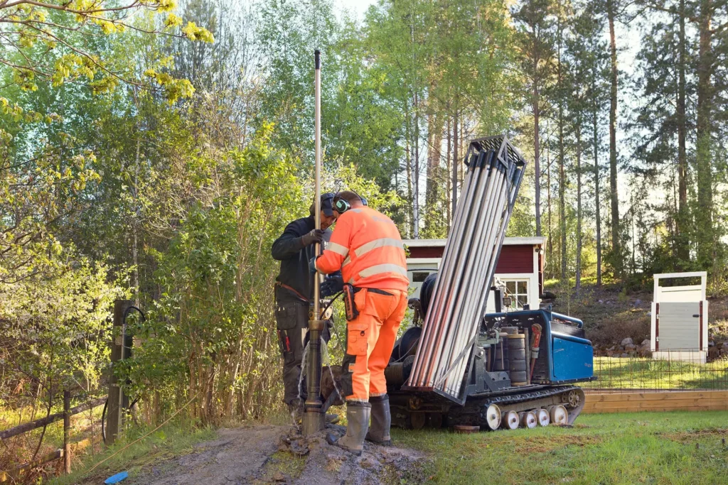 Två personer utomhus som jobbar med kapacitetshöjning av vatten genom tryckning