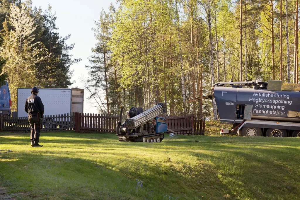 Person vid maskin utomhus som skapar kapacitetshöjning av vatten genom tryckning
